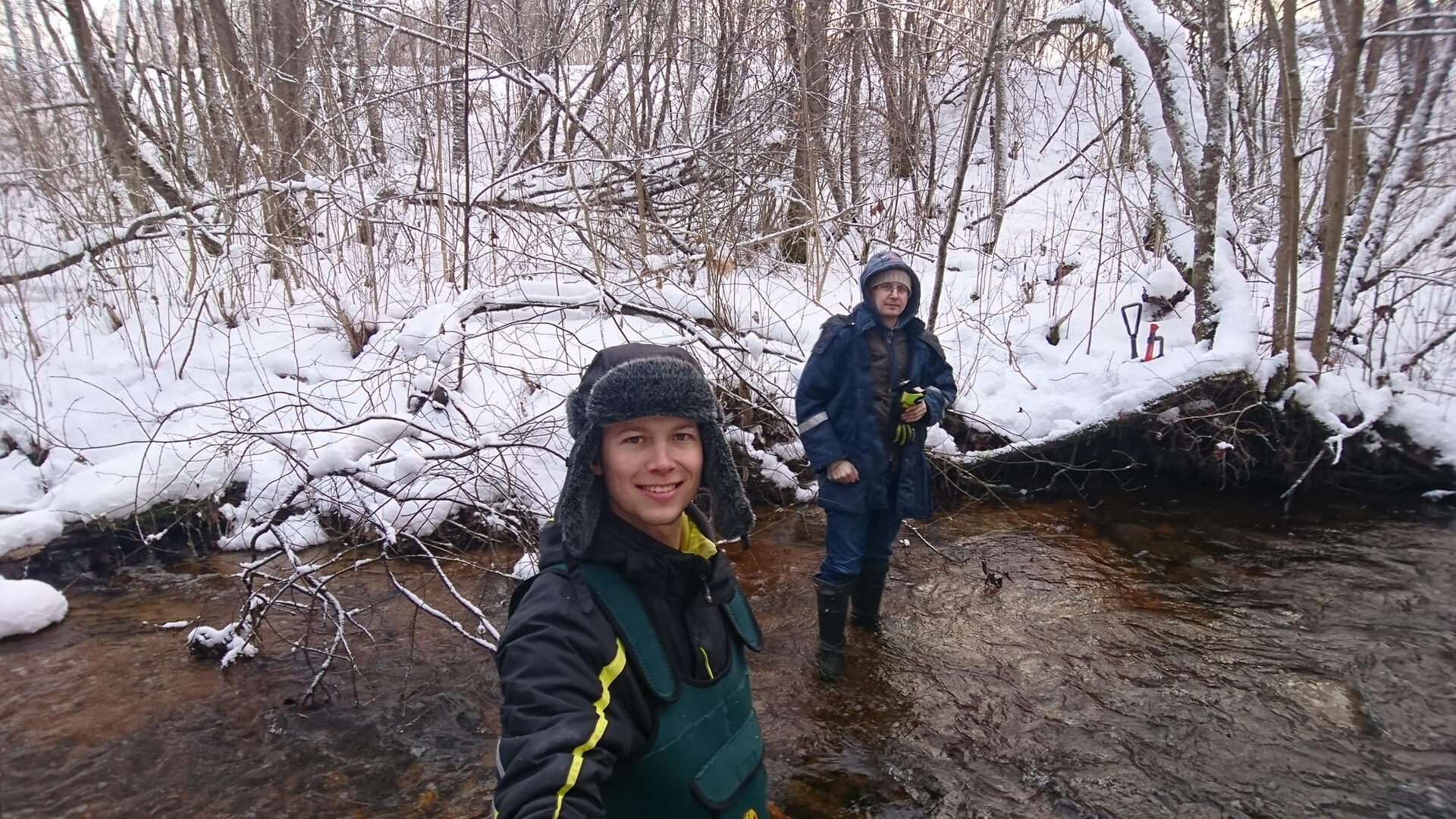 scientists' selfie on a river during winter