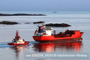 a red cargo ship at sea